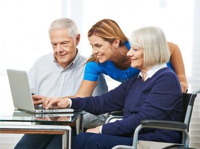 Younger woman helping older couple on a laptop