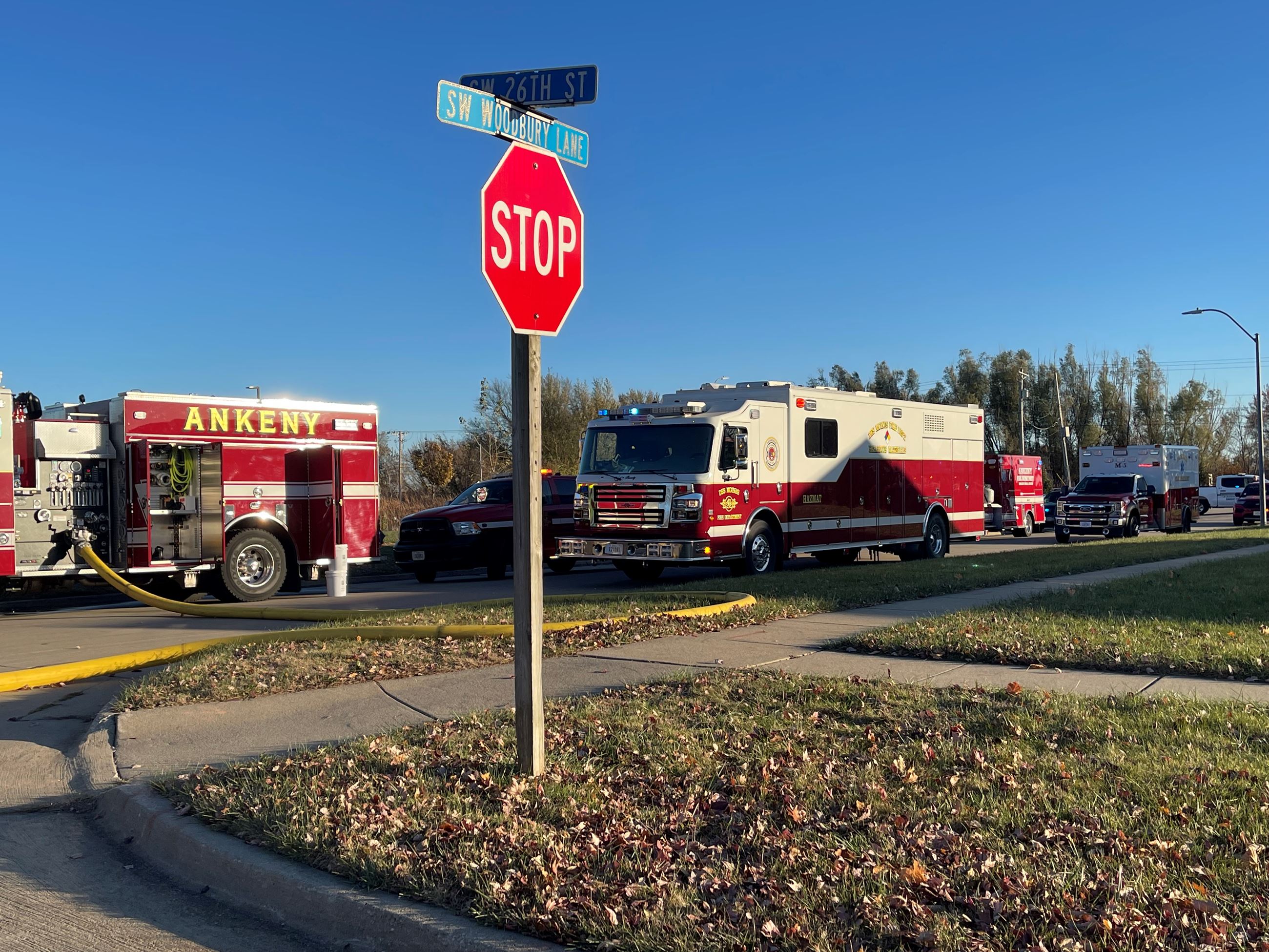 Two red fire truck at an intersection parked